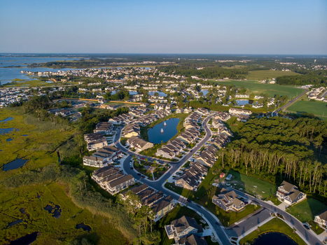 Ocean City Maryland United States 28 July 2019 Aerial view of a residential neighborhood with suburban houses a central pond with a fountain and surrounding wetlands.