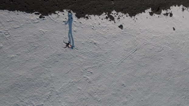 Aerial view of a person walking on snow near Rifugio Sapienza Italy. Aerial view of a person walking on snow near Rifugio Sapienza Italy.