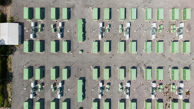 Aerial view of a modern Battery Energy Storage System installation with rows of green containers and electrical infrastructure in Tavazzano con Villavesco Lombardy Italy.