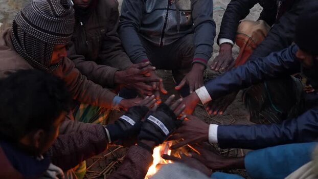 View of people warming hands by a fire in Bogura Bangladesh. View of people warming hands by a fire in Bogura Bangladesh.