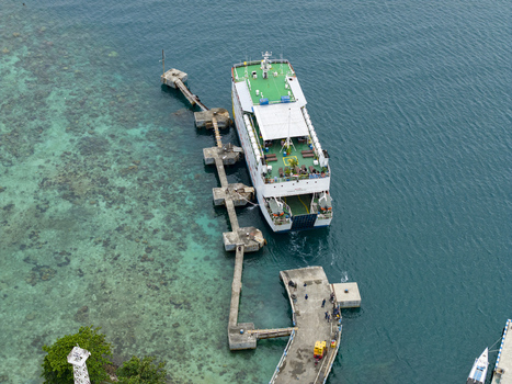 Aerial view of a ferry docked at the Karimunjawa ferry harbour the turquoise waters contrasting with the lush greenery Karimunjawa Jawa Tengah Indonesia. Aerial view of a ferry docked at the Karimunjawa ferry harbour the turquoise waters contrasting with the lush greenery Karimunjawa Jawa Tengah Indonesia.