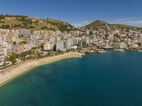 Aerial view of the coastal city of Saranda with its sandy beach turquoise waters and dense urban development climbing the hillside in Saranda Vlore County Albania. Aerial view of the coastal city of Saranda with its sandy beach turquoise waters and dense urban development climbing the hillside in Saranda Vlore County Albania.