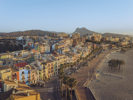 Aerial view of the iconic colorful houses along the waterfront and sandy beach with palm trees in La Vila Joiosa Valencian Community Spain. Aerial view of the iconic colorful houses along the waterfront and sandy beach with palm trees in La Vila Joiosa Valencian Community Spain.