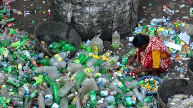 View of a woman sorting plastic bottles for recycling Bangladesh. View of a woman sorting plastic bottles for recycling Bangladesh.