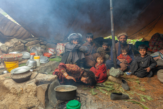 Skardu Gilgit Baltistan Pakistan 03 July 2010 View of shepherds including men women and children gathered inside a tent in Deosai National Park preparing a meal over a small stove.