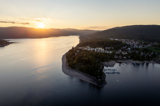 Aerial view of Schluchsee lake at sunset with golden light reflecting on the water forested hills and the lakeside village Schluchsee Baden Wurttemberg Germany. Aerial view of Schluchsee lake at sunset with golden light reflecting on the water forested hills and the lakeside village Schluchsee Baden Wurttemberg Germany.