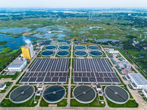 Aerial view of the Sewage Treatment Plant Dhaka WASA featuring circular clarifiers and rectangular aeration tanks surrounded by green wetlands in Dhaka Dhaka Division Bangladesh. Aerial view of the Sewage Treatment Plant Dhaka WASA featuring circular clarifiers and rectangular aeration tanks surrounded by green wetlands in Dhaka Dhaka Division Bangladesh.