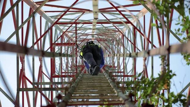 View of a technician climbing a telecommunications tower Bangladesh. View of a technician climbing a telecommunications tower Bangladesh.