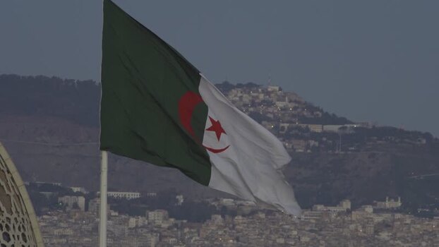 Aerial view of the Algerian flag waving over a city Algeria.