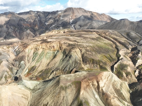 Aerial view of Landmannalaugar showing the colorful rhyolite mountains rugged volcanic terrain and dramatic geological formations in Hella Rangarthing ytra Iceland. Aerial view of Landmannalaugar showing the colorful rhyolite mountains rugged volcanic terrain and dramatic geological formations in Hella Rangarthing ytra Iceland.