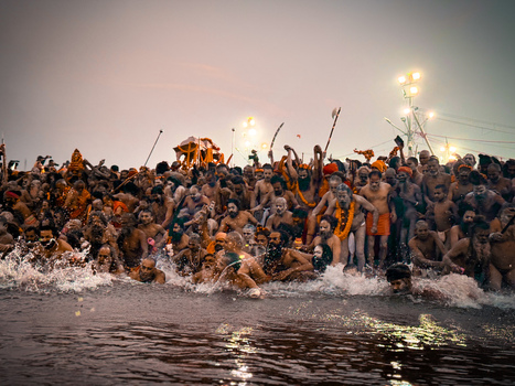 Prayagraj India 05 February 2025 View of a large crowd of sadhus and devotees bathing in the holy waters of the Triveni Sangam during a religious festival at dusk.