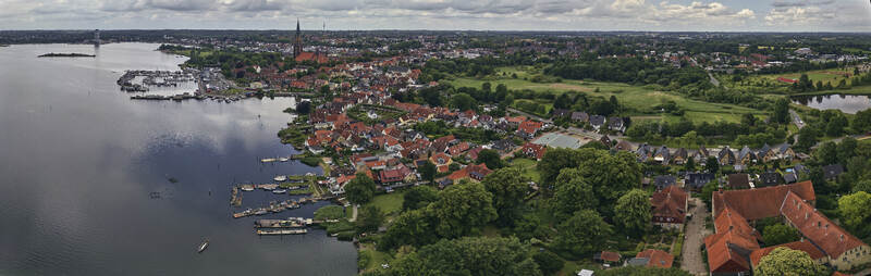 Schleswig Germany 01 July 2026 Aerial view of the Holm fishing village and historic St Johannis kloster along the Schlei with traditional houses and the city skyline.