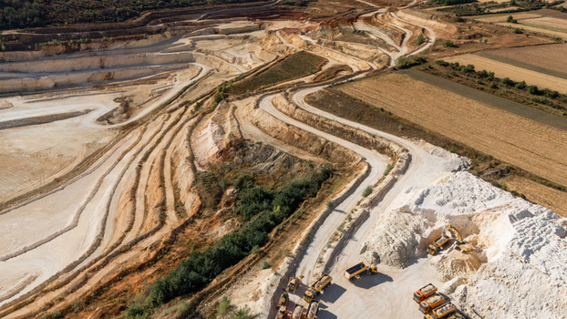 Aerial view of the Besenovo quarry showing terraced limestone extraction levels heavy machinery and trucks working on the site in Besenovo Vojvodina Serbia. Aerial view of the Besenovo quarry showing terraced limestone extraction levels heavy machinery and trucks working on the site in Besenovo Vojvodina Serbia.