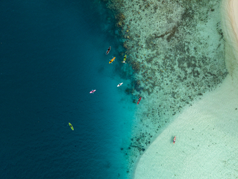Aerial view of kayaks floating on the turquoise waters near Menjangan Kecil Island where the ocean s depths meet the coral reefs Karimunjawa Central Java Indonesia.