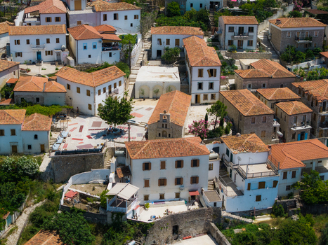 Aerial view of the traditional white houses terracotta rooftops and a small stone church in the historic village of Dhermi Vlore County Albania. Aerial view of the traditional white houses terracotta rooftops and a small stone church in the historic village of Dhermi Vlore County Albania.