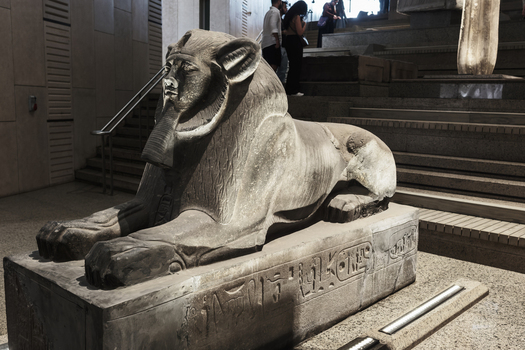 Giza Egypt 16 May 2026 View of a majestic stone sphinx statue with hieroglyphics on its base inside the Grand Egyptian Museum with visitors in the background.