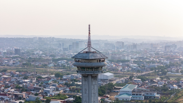 Aerial view of the observation tower overlooking the sprawling cityscape and residential rooftops in Semarang Central Java Indonesia. Aerial view of the observation tower overlooking the sprawling cityscape and residential rooftops in Semarang Central Java Indonesia.