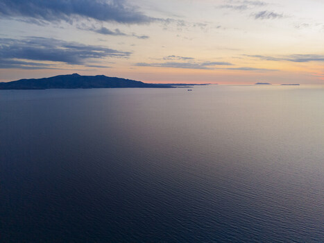 Aerial view of the Ionian Sea coastline at sunset with calm waters and distant hills Saranda Vlore County Albania. Aerial view of the Ionian Sea coastline at sunset with calm waters and distant hills Saranda Vlore County Albania.
