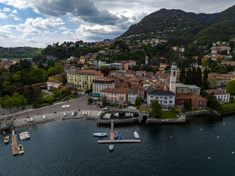 Aerial view of Villa d Este and the historic waterfront with boats moored at the pier and the church tower in Cernobbio Lombardia Italy. Aerial view of Villa d Este and the historic waterfront with boats moored at the pier and the church tower in Cernobbio Lombardia Italy.