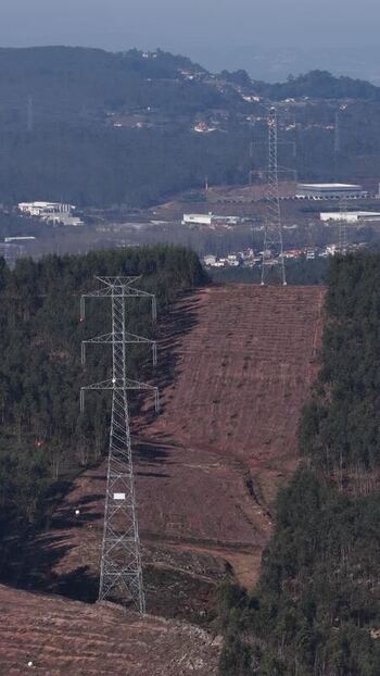Aerial view of power lines cutting through forest Portugal.