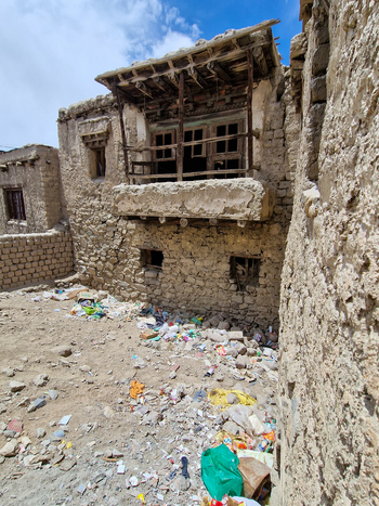 View of traditional mud brick architecture with a wooden balcony in the historic old town of Leh Ladakh India.