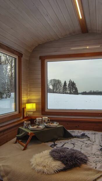 View of cozy cabin interior with snowy landscape in Latvia. View of cozy cabin interior with snowy landscape in Latvia.