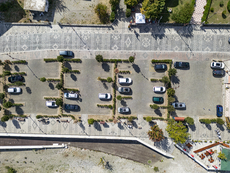 Aerial view of a parking lot with cars parked in marked spaces and patterned pavement in Shiroke Qarku i Shkodres Albania. Aerial view of a parking lot with cars parked in marked spaces and patterned pavement in Shiroke Qarku i Shkodres Albania.