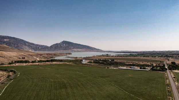 Aerial view of the Shoshone River and Buffalo Bill Reservoir surrounded by arid hills and green fields in Cody Wyoming United States.