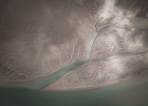 Aerial view of the Rogerstown Estuary showing intricate branching water channels and dendritic patterns across the mudflats in Lusk County Dublin Ireland. Aerial view of the Rogerstown Estuary showing intricate branching water channels and dendritic patterns across the mudflats in Lusk County Dublin Ireland.