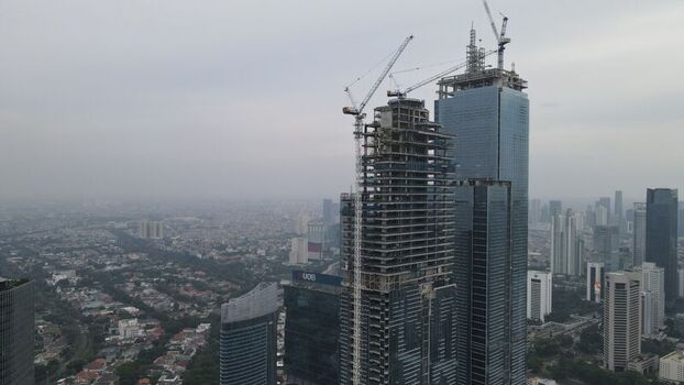 Kecamatan Menteng Indonesia 03 December 2021 Aerial view of skyscrapers under construction with tower cranes in Jakarta Pusat featuring dense urban development under a cloudy sky. Kecamatan Menteng Indonesia 03 December 2021 Aerial view of skyscrapers under construction with tower cranes in Jakarta Pusat featuring dense urban development under a cloudy sky.