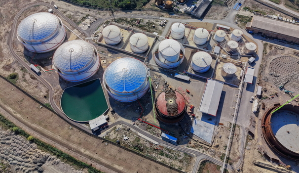 Aerial view of fuel tanks at an industrial facility with large storage containers a green reservoir and construction equipment in Kovin Vojvodina Serbia. Aerial view of fuel tanks at an industrial facility with large storage containers a green reservoir and construction equipment in Kovin Vojvodina Serbia.