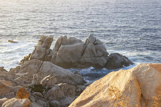 View of the unique granite rock formations overlooking the blue Mediterranean Sea during golden hour Capo Testa Sardegna Italy. View of the unique granite rock formations overlooking the blue Mediterranean Sea during golden hour Capo Testa Sardegna Italy.