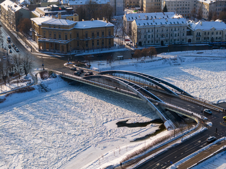 Aerial view of Mindaugas Bridge over the frozen Neris River with ice floes and snow covered banks in Vilnius County Lithuania.