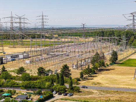 Aerial view of Amprion Umspannwerk electrical substation with high voltage power lines and towers surrounded by agricultural fields in Pfungstadt Hessen Germany.