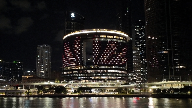 View of the illuminated Queen s Wharf Brisbane development at night with modern skyscrapers and the Brisbane River in the foreground in Brisbane Queensland Australia. View of the illuminated Queen s Wharf Brisbane development at night with modern skyscrapers and the Brisbane River in the foreground in Brisbane Queensland Australia.