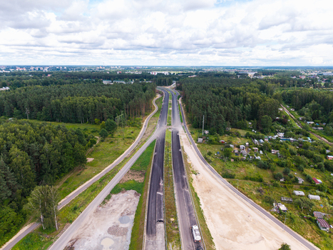 Aerial view of the Southern Bridge project construction site featuring newly paved road sections surrounding forest and infrastructure development in Riga Latvia. Aerial view of the Southern Bridge project construction site featuring newly paved road sections surrounding forest and infrastructure development in Riga Latvia.