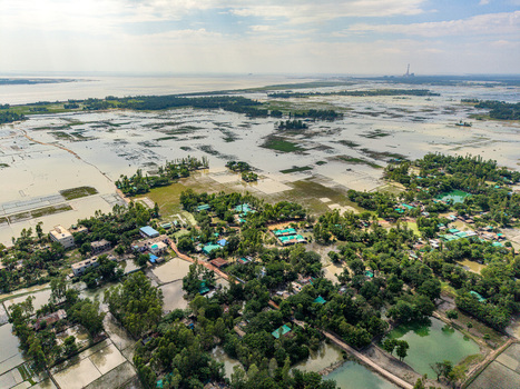 Aerial view of the flooded rural landscape with scattered houses lush green trees and water covered agricultural fields in Banshkhali Upazila Chittagong Division Bangladesh. Aerial view of the flooded rural landscape with scattered houses lush green trees and water covered agricultural fields in Banshkhali Upazila Chittagong Division Bangladesh.
