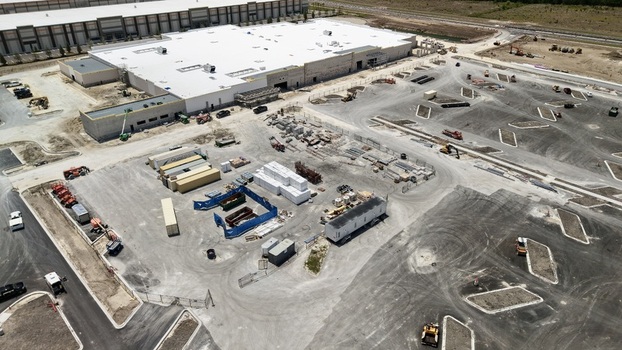 Aerial view of the construction site at Foundry Lane featuring large industrial buildings heavy machinery and building materials in World Golf Village Florida United States.