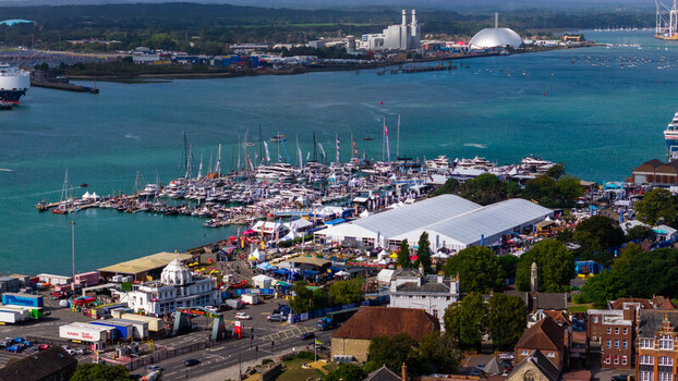 Aerial view of the Southampton International Boat Show featuring yachts docked in the marina and large white exhibition marquees along the waterfront in Southampton England United Kingdom. Aerial view of the Southampton International Boat Show featuring yachts docked in the marina and large white exhibition marquees along the waterfront in Southampton England United Kingdom.