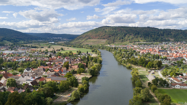 Aerial view of the town of Kleinheubach situated along the Main river featuring historic architecture lush green trees and rolling hills in Kleinheubach Bavaria Germany.