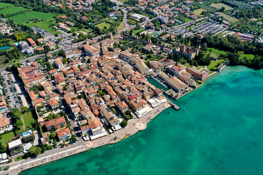 Aerial view of Lazise town with its historic harbor and medieval walls along the turquoise shores of Lake Garda Provincia di Verona Veneto Italy.