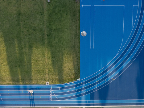 Aerial view of a blue running track with numbered lanes adjacent to a green grass field Santo Domingo Distrito Nacional Dominican Republic.