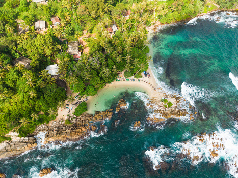 Aerial view of Secret Beach Mirissa featuring turquoise waters and rocky coastline surrounded by lush palm trees Mirissa Southern Province Sri Lanka. Aerial view of Secret Beach Mirissa featuring turquoise waters and rocky coastline surrounded by lush palm trees Mirissa Southern Province Sri Lanka.