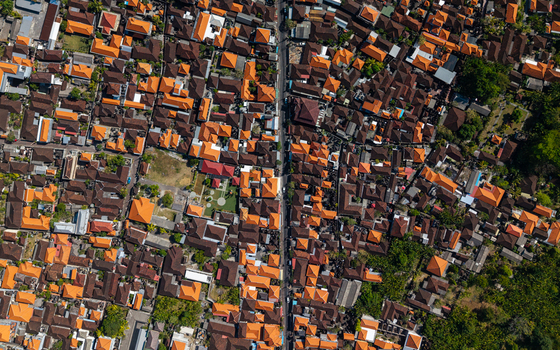 Aerial view of the dense residential area with traditional orange tiled roofs and narrow streets in Kecamatan Kuta Selatan Bali Indonesia.