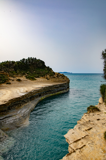 Aerial view of the turquoise waters of the Canal d Amour coastal rock formations with lush greenery and clear sky in Corfu Ionian Islands Greece. Aerial view of the turquoise waters of the Canal d Amour coastal rock formations with lush greenery and clear sky in Corfu Ionian Islands Greece.