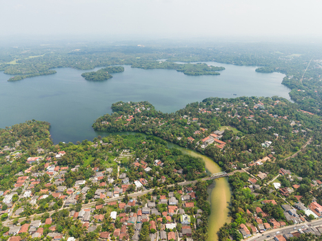 Aerial view of the lush tropical landscape and residential houses surrounding Dodanduwa Lake under a hazy sky Dodanduwa Southern Province Sri Lanka. Aerial view of the lush tropical landscape and residential houses surrounding Dodanduwa Lake under a hazy sky Dodanduwa Southern Province Sri Lanka.