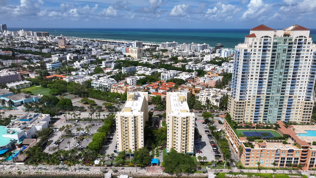 Aerial view of Miami Beach featuring high rise residential buildings lush palm trees and the Atlantic Ocean coastline in Miami Beach Florida United States.