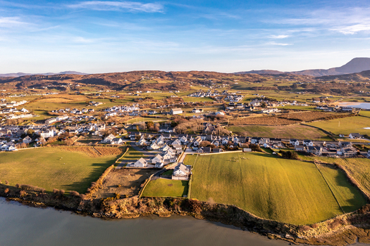 Aerial view of the coastal village of Dunfanaghy with its charming houses green fields and rugged landscape along the Atlantic coast in Dunfanaghy County Donegal Ireland. Aerial view of the coastal village of Dunfanaghy with its charming houses green fields and rugged landscape along the Atlantic coast in Dunfanaghy County Donegal Ireland.