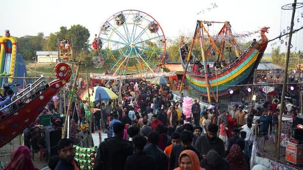 View of a crowded amusement park with a Ferris wheel Bangladesh. View of a crowded amusement park with a Ferris wheel Bangladesh.