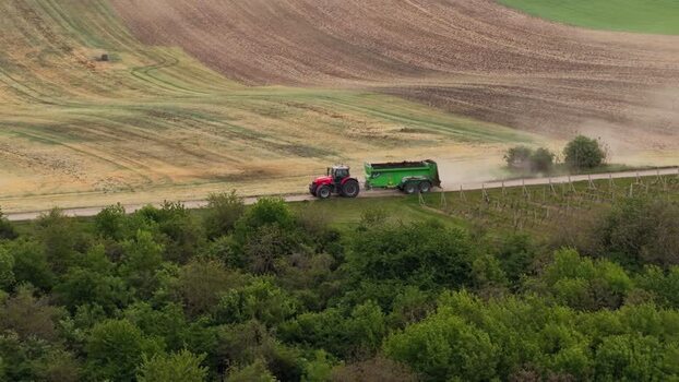 Aerial view of a tractor driving through rolling fields Czechia.